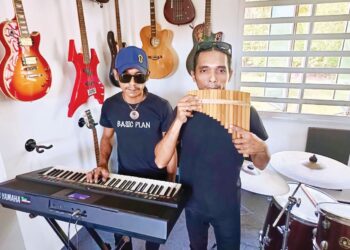 MOHD. Faizul Mokhtar (kanan) berlatih meniup seruling kuali buluh bersama kembarnya, Mohd. Faizal di Kuala Perlis. – UTUSAN