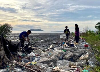 SEKUMPULAN kanak-kanak mengutip sampah hanyut yang memenuhi pantai Pulau Ketam di Kuala Perlis, semalam. – UTUSAN/IZLIZAN OTHMAN
