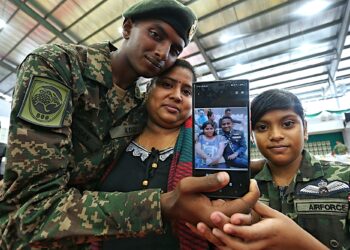 K. INDIRAN (kiri) dan ibunya, S. Usha menunjukkan gambar mendiang bapanya ketika ditemui pada majlis Perbarisan Tamat Latihan Perajurit Muda Lelaki Siri 200/2024 di Padang Kawad Pusasda, Port Dickson hari ini.-UTUSAN/MOHD. SHAHJEHAN MAAMIN.