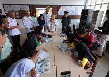 Wong Kah Woh (tengah)  menyantuni murid-murid SK RPS Banun semasa mengadakan lawatan kerja ke sekolah berkenaan dekat Gerik, Perak hari ini. - UTUSAN/FADZIL ZAINOL