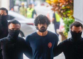 MUHAMMED Yusoff Rawther diiringi anggota polis ketika hadir di Mahkamah Majistret Kuala Lumpur hari ini atas tuduhan mengedar dadah, Jumaat lalu.