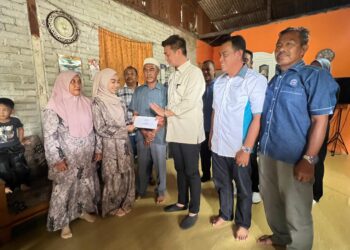 MUHAMMAD Faiz Fadzil (tiga dari kanan) menyampaikan sumbangan kepada Wan Nur'alyaa Syaza di Tok Bali, Pasir Puteh, Kelantan hari ini. UTUSAN/TOREK SULONG.