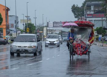 SEORANG pengayuh beca sedang mengayuh becanya di Banda Hilir, Melaka. - UTUSAN/SYAFEEQ AHMAD