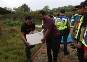 ANGGOTA polis membawa barang bukti yang ditemukan ditanam dan dibakar tepi sungai Kampung Panji, Kota Bharu, Kelantan hari ini.
