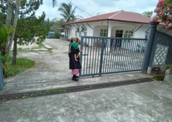 ANAK kepada isteri kedua CEO GISBH menutup pagar rumah selepas ditemui pemberita di Kampung Panji, Kota Bharu, Kelantan hari ini-UTUSAN/ROHANA MOHD. NAWI.