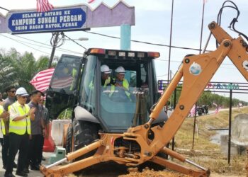 AHMAD Zahid Hamidi mengendalikan jentolak ketika melakukan pecah tanah projek membina dan menaik taraf jalan utama Parit 1 - Parit 10 Kampung Sungai Pergam di Bagan Datuk hari ini. - UTUSAN/AIN SAFRE BIDIN