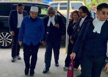 EBIT Lew diiringi oleh Ram Singh (tiga, kiri) dan barisan peguamnya semasa tiba di Mahkamah Majistret Tenom, hari ini