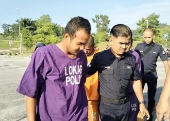 WAN Abd. Qayyum Wan Mohd. Radzuan (kiri) didakwa memfitnah anggota polis yang terkorban dalam serangan Balai Polis Ulu Tiram dituduh di Mahkamah Majistret Tapah hari ini. - UTUSAN