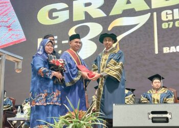 CHE Rahim Daud (kanan) menyampaikan Sijil Eksekutif kepada graduan GiatMara di Dewan Tengku Canselor UMK Bachok, Kelantan, semalam. – UTUSAN/TOREK SULONG