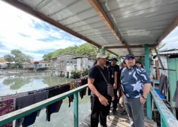 SHAHELMEY Yahya (kanan) diiringi Osman Omar Khan (kiri) melawat Kampung Sembulan Tengah di Kota Kinabalu, hari ini.