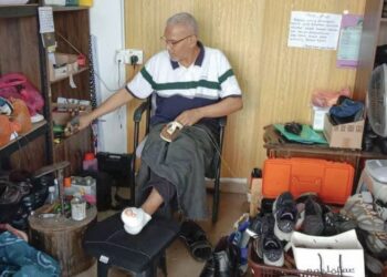 ABDUL Shariff Jamaludin yang kehilangan dua jari kaki kiri akibat komplikasi kencing manis membaiki kasut di Terminal Bas Baharu Jerantut di Jerantut, Pahang.