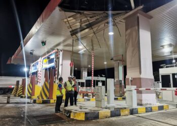 JURUTERA  LPT2 memeriksa struktur  bumbung Plaza Tol Telemong yang mengalami kerosakan dalam kejadian ribut di Kuala Terengganu, malam tadi. - UTUSAN/KAMALIZA KAMARUDDIN