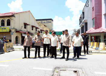 AHMAD MASLAN (tengah) meninjau penyuraian baru aliran trafik satu hala di Tapah hari ini. - UTUSAN