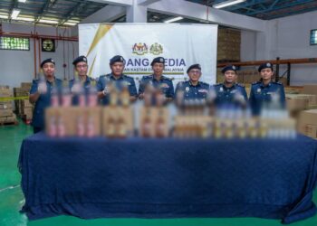 ABDUL Ghafar Mohamad (tengah) menunjukkan minuman keras yang dirampas dalam tiga serbuan berasingan di Kuala Lumpur dan Perak, minggu lalu. - UTUSAN