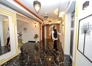 Penduduk, Nor Hidayah Sulaiman menunggu lif di ruang dekorasi bertemakan lobi hotel di tingkat enam blok D di Projek Perumahan Rakyat (PPR) Lembah Subang 1, semalam. – UTUSAN/ FARIZ RUSADIO