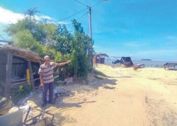 JEFRYDIN Rashid menunjukkan kedudukan rumahnya yang terletak di tepi pantai di Kampung Pengkalan Atap, Kuala Besut, Besut, semalam. – UTUSAN/WAN ZURATIKAH IFFAH WAN ZULKIFLI