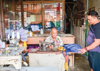 NYAM Fock Suan tekun menjahit pakaian pelanggan di kedainya di Gong Kapas, Kuala Terengganu, semalam. – UTUSAN/PUQTRA HAIRRY ROSLI