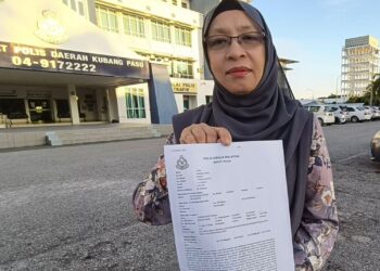ZURAINI Kamal menunjukkan laporan polis dibuatnya terhadap seorang pelajar yang didakwa menipu di IPD Kubang Pasu kelmarin.