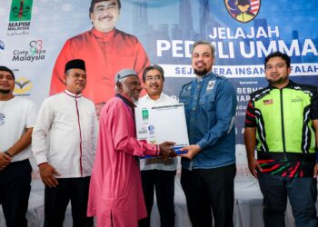 Johari Abdul Ghani menyaksikan Setiausaha Agung Mapim, Faris Hussain menyampaikan kotak bantuan asnaf kepada salah seorang penerima pada Program Jelajah Peduli Ummah di Marasatul Khairat, Desa Pandan, Kuala Lumpur, hari ini. -UTUSAN/MUHAMAD IQBAL ROSLI