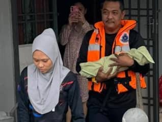 SEORANG ibu dan bayinya di Kampung Parit Jepun, Simpang Renggam dipindahkan selepas kediaman mereka dilanda banjir.