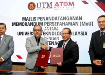 IBRAHIM Muhamad (dua dari kiri) dan MOHD. SHAFRY Mohd. Rahim bertukar dokumen MoU di UTM Skudai, Johor Bahru.