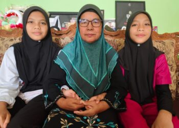 NUR Jihan Irdina Mohd. Junaizi (kiri) dan  Nur Anis Zahra Nazihah Mohd. Junaizi  (kanan) bersama nenek mereka, Asmah Abu Bakar di Kampung Payang Kayu, Hulu Terengganu semalam.