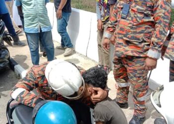 ANGGOTA bomba menenangkan seorang remaja selepas diselamatkan daripada cubaan terjun dari Jambatan Tendong, Kota Bharu, Kelantan, kelmarin.