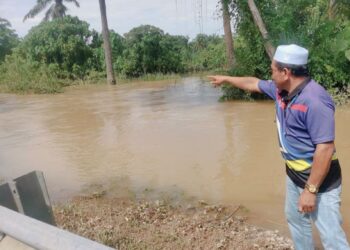 PENDUDUK menunjukkan anak sungai di mana buaya ditemukan  di Kampung Pasir Jenderis, Pasir Salak, Perak. – UTUSAN/AIN SAFRE BIDIN