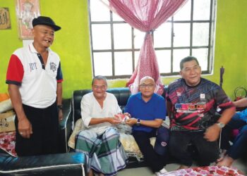 MOHD. Youzaimi Yusof (dua dari kanan) menyampaikan sumbangan kepada Rasidek MT. Jani 
di kediamannya di Felda Tenggaroh 4, Mersing, Johor, semalam.
