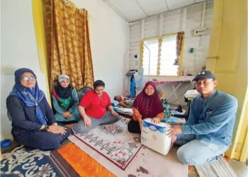 ROSLIZA Ismail (dua, kanan) menerima sumbangan Pertubuhan Amal Bakti Mersing di rumah sewanya di Kampung Pengkalan Batu, Mersing.