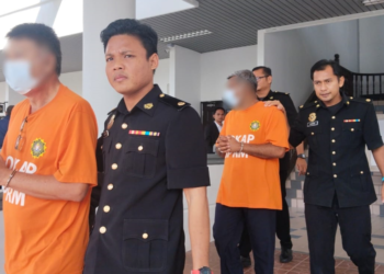 SUSPEK diiringi pegawai Suruhanjaya Pencegahan Rasuah Malaysia (SPRM) ketika hadir ke Mahkamah Majistret, Ayer Keroh, Melaka bagi mendapatkan perintah reman. - UTUSAN/MUHAMMAD SHAHIZAM TAZALI