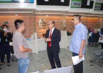 NGWE Hee Sem berbual dengan seorang pelanggan di Pejabat Perkeso, Ayer Keroh, Melaka. - UTUSAN/AMRAN MULUP