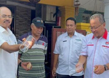 RAZALI Kassim (kiri) dan Rusdi Abdul Rahman (kanan) melepaskan nyamuk Aedes berWolbachia di Taman Pasdec Makmur Indera Mahkota 2, Kuantan, semalam.
