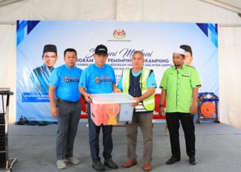 Saifuddin Nasution Ismail (dua kiri) menyampaikan sumbangan peralatan kepada wakil Skim Rondaan Sukarela (SRS) selepas merasmikan Santuni Madani: Program Satu Kampung MCBA di Kampung Bukit Tiu, Machang, Kelantan hari ini-UTUSAN/KAMARUL BISMI KAMARUZAMAN.