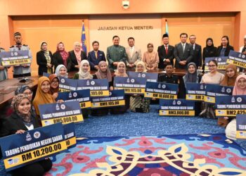 MOHD. Arifin Mohd. Arif merakam gambar kenangan bersama pelajar yang menerima bantuan TPNS di Menara Kinabalu, Sabah, hari ini.