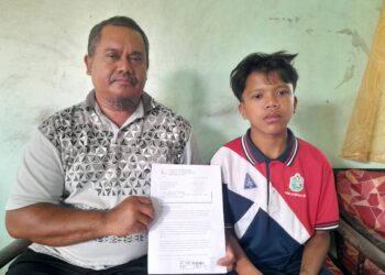 R I AFZANIZAM Isa menunjukkan surat daripada HSA untuk merujuk anaknya, Amierul ke IJN yang menghadapi masalah injap jantung di Parit Ali 2, Kampung Dalam Ayer Baloi, Pontian.