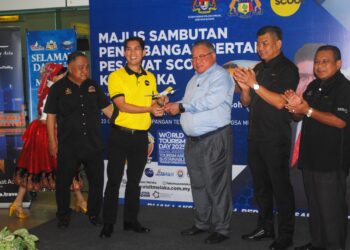 TIONG King Sing menerima replika pesawat Embraer E190-E2 disampaikan Ketua Pegawai Komersial Scoot Pte. Ltd., Calvin Chan pada Majlis Sambutan Penerbangan Pertama Pesawat Scoot di LTAM, Batu Berendam, Melaka. - UTUSAN/AMRAN MULUP