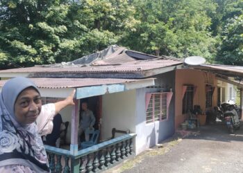 NORIDAH Mat Diah menunjukkan bumbung rumahnya yang rosak ketika ditemui di Kampung Pantai Puteri, Melaka. - UTUSAN/HADI AB. MANAP