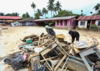 KAKITANGAN SK Lintang mengumpul peralatan dan barangan yang rosak akibat banjir di Sungai Siput ketika tinjauan hari ini. - UTUSAN/MUHAMAD NAZREEN SYAH MUSTHAFA