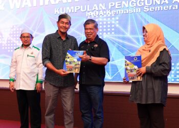 MOHAMAD Sabu (dua kanan) menyerahkan  Watikah Kumpulan Pengguna Air (KPA) Kawasan Pembangunan Pertanian Bersepadu (IADA) Kemasin-Semerak kepada salah seorang penerima di Pasir Puteh, Kelantan, hari ini. UTUSAN/KAMARUL BISMI KAMARUZAMAN