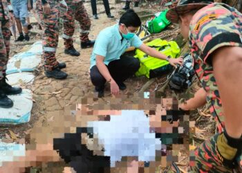 PEGAWAI perubatan memeriksa lelaki yang mengalami sesak nafas dan disahkan meninggal dunia ketika mendaki Bukit Kledang di Ipoh hari ini. - UTUSAN/IHSAN JBPM