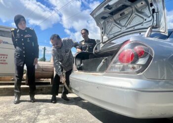 HASBULLAH Abd. Rashid memeriksa tangki tambahan pada kenderaan ditahan dalam operasi di sebuah stesen minyak sekitar Jalan Kaki Bukit, Kangar, Perlis, hari ini. -UTUSAN/ASYRAF MUHAMMAD