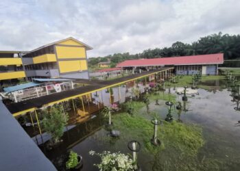 KEADAAN banjir yang menjejaskan sesi persekolahan pelajar SMK Lambor Kiri dekat Parit. - UTUSAN