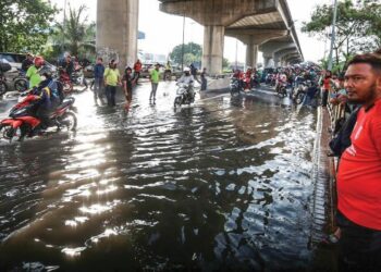 LIMPAHAN air dekat Jalan Kem akibat fenomena air laut pasang besar menyebabkan pengguna jalan raya memberhentikan kenderaan mereka sementara menunggu air surut di Pelabuhan Klang, di Klang, Selangor, semalam. - UTUSAN/AFIQ RAZALI