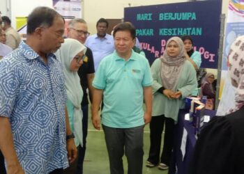 ZAMBRY Abd. Kadir melawat pameran dan beramah mesra dengan pengunjung pada program khidmat masyarakat HCTM di Dewan Komuniti Batu 10, Lekir di Lumut hari ini. - UTUSAN