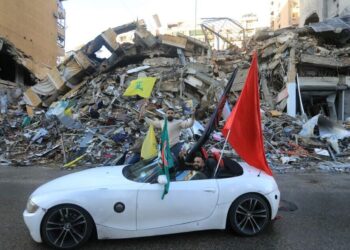SEORANG pemandu mengibarkan bendera Hezbollah ketika menyertai perarakan di pinggir bandar selatan Beirut.-AFP