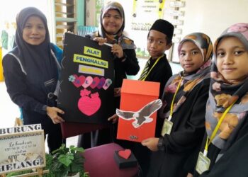 MURID-MURID SK Kampung Sawah menunjukkan alat untuk menghalau burung merpati ciptaan mereka.