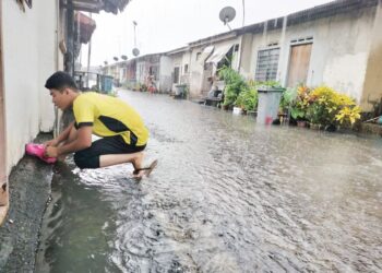 SEORANG penduduk di Jalan Talapia menutup saluran air mesin basuh di rumahnya selepas melihat air melimpah dari longkang di belakang rumahnya.