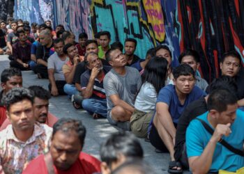 SEBAHAGIAN warga asing yang diperiksa dalam operasi bersepadu di Jalan Changkat, Kuala Lumpur, semalam. – UTUSAN/FARIZ RUSADIO