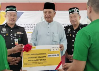 MOHD. Zahidi Zainuddin (tengah) menyampaikan sumbangan daripada Sultan Nazrin Muizzuddin Shah bagi penyediaan jamuan makan tengah hari untuk prospek di Pusat Koreksional Kamunting  di Taiping hari ini. - UTUSAN/WAT KAMAL ABAS